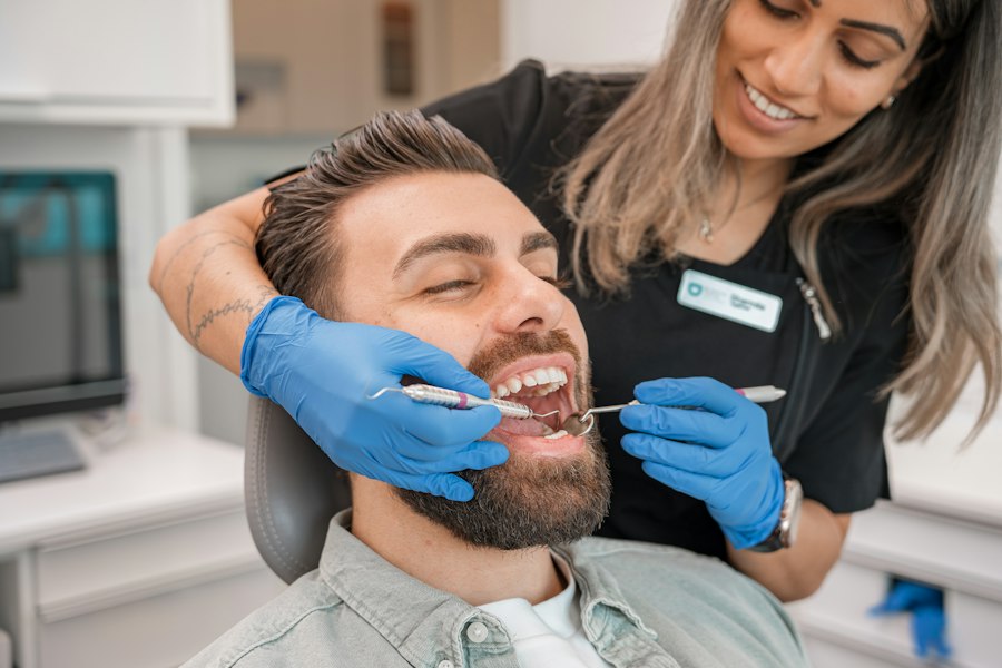 A man smiling in the chair while a hygienist works