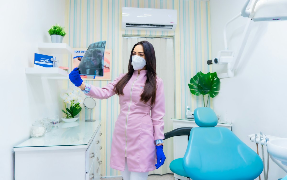 A dentist standing in a bright practice room