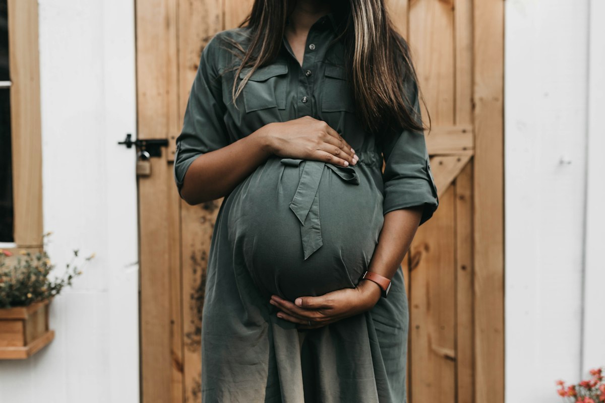 a pregnant woman standing in a doorway