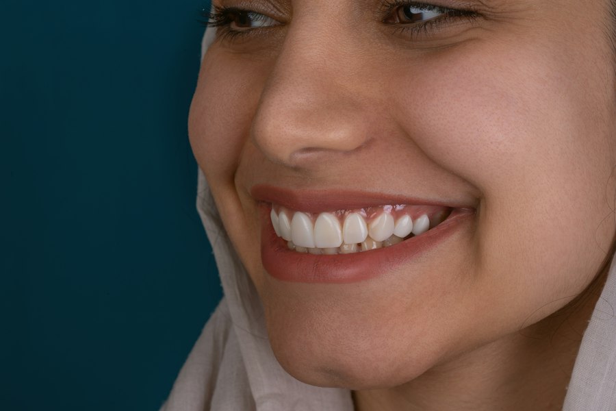 A close smile against a teal background