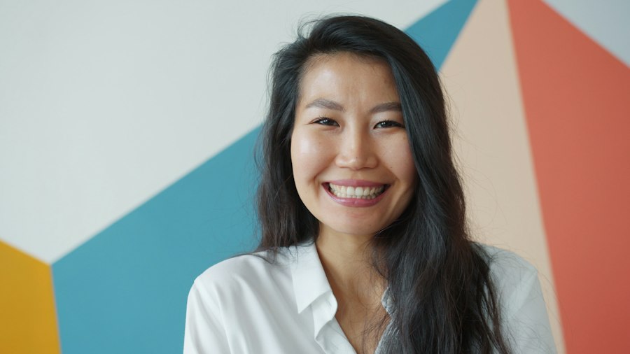 A woman smiling in front of a painted wall